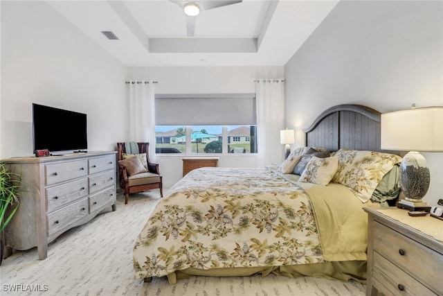 bedroom featuring ceiling fan and a raised ceiling