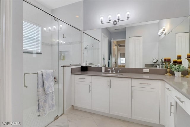 bathroom with a shower with shower door and vanity