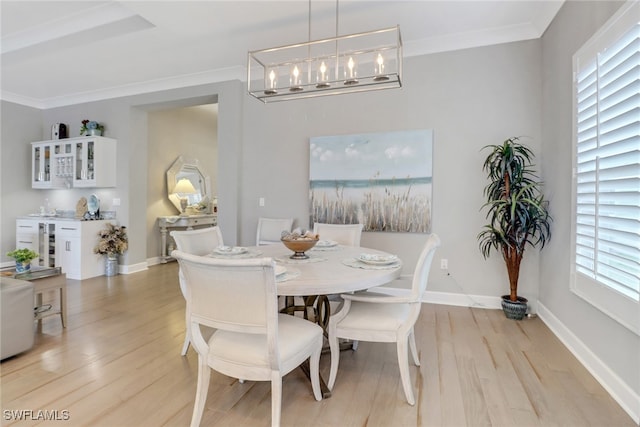 dining space featuring wine cooler, an inviting chandelier, ornamental molding, and light hardwood / wood-style floors