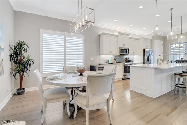 dining area featuring light wood-type flooring and an inviting chandelier