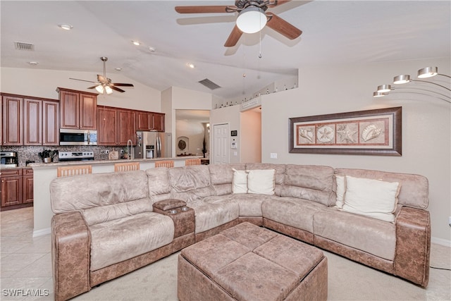 living room featuring ceiling fan, light tile patterned floors, vaulted ceiling, and sink