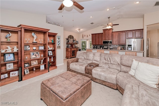 living room featuring ceiling fan, vaulted ceiling, and light carpet