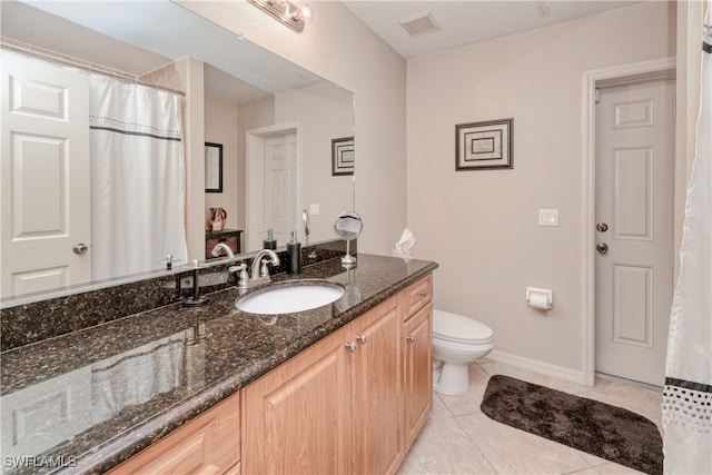 bathroom featuring toilet, vanity, and tile patterned floors