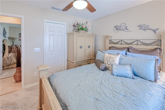 bedroom with ceiling fan, light colored carpet, and a closet