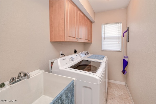 laundry room featuring cabinets, independent washer and dryer, and sink