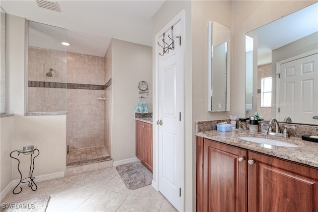 bathroom featuring vanity, tile patterned floors, and tiled shower