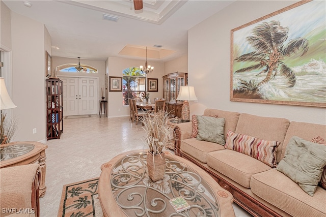 living room with light tile patterned floors, a tray ceiling, and a chandelier