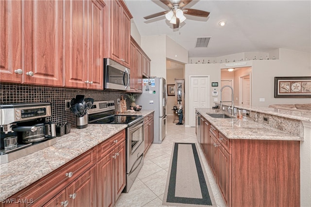 kitchen with appliances with stainless steel finishes, tasteful backsplash, sink, light stone counters, and light tile patterned floors