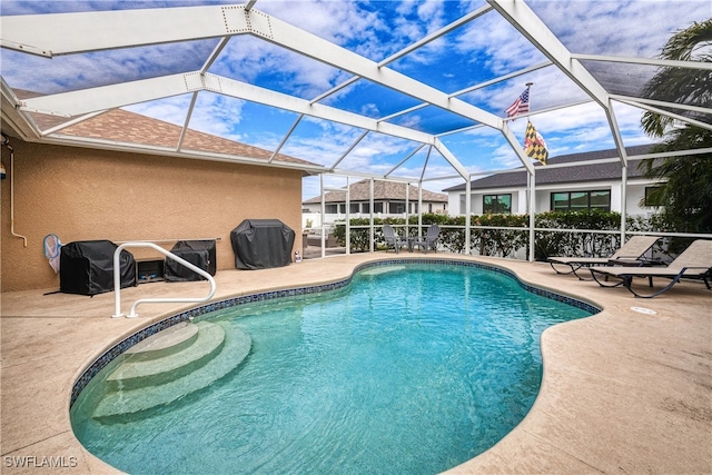 view of pool featuring glass enclosure and a patio