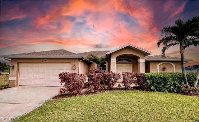 ranch-style home with a garage and a lawn