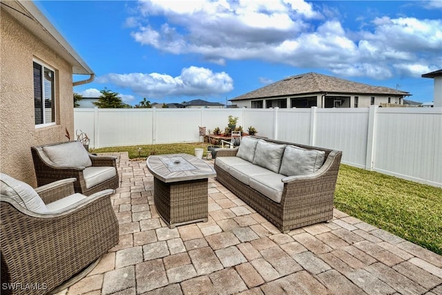 view of patio with an outdoor living space with a fire pit