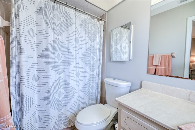 bathroom featuring vanity, toilet, and curtained shower