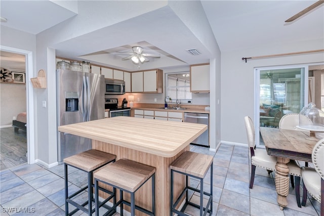 kitchen featuring ceiling fan, stainless steel appliances, sink, and light tile patterned floors