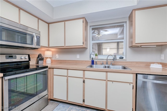 kitchen with stainless steel appliances, sink, white cabinets, and ceiling fan