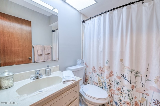 bathroom with vanity, curtained shower, a skylight, and toilet