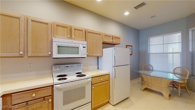 kitchen featuring light brown cabinetry and white appliances