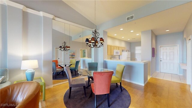 dining room featuring lofted ceiling, light wood-type flooring, and a chandelier