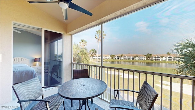 balcony featuring ceiling fan and a water view