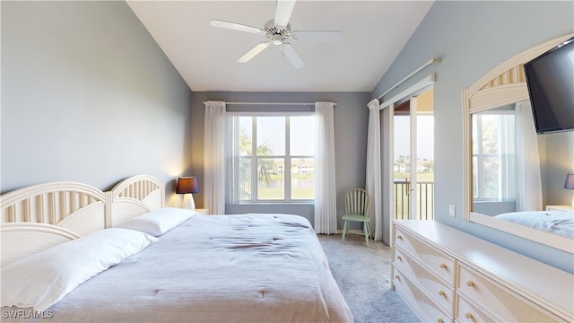 carpeted bedroom with ceiling fan, vaulted ceiling, and access to outside