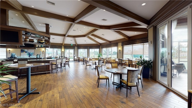 dining space with light hardwood / wood-style floors and beam ceiling