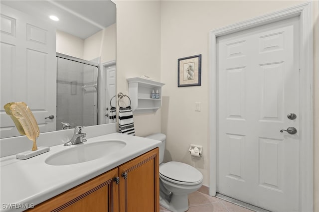 bathroom featuring tile patterned flooring, vanity, a shower with door, and toilet