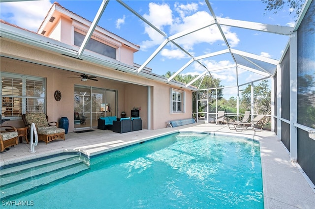 view of pool with ceiling fan, outdoor lounge area, glass enclosure, and a patio area