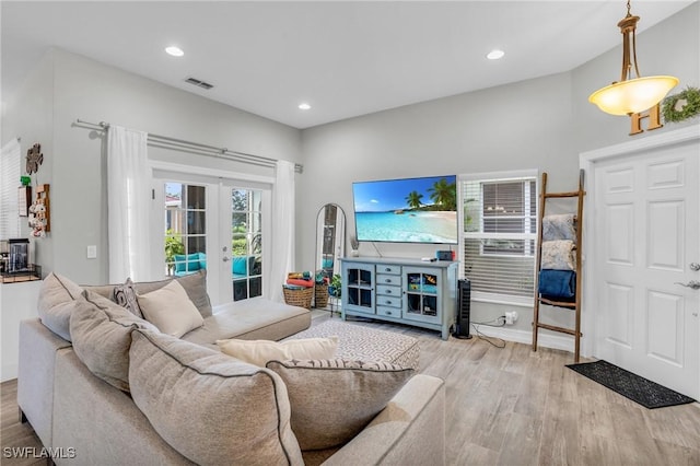 living room with light hardwood / wood-style flooring and french doors