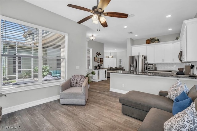 living room featuring light hardwood / wood-style flooring and ceiling fan