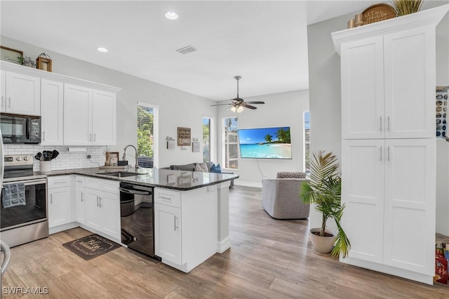 kitchen with white cabinetry, sink, black appliances, and kitchen peninsula