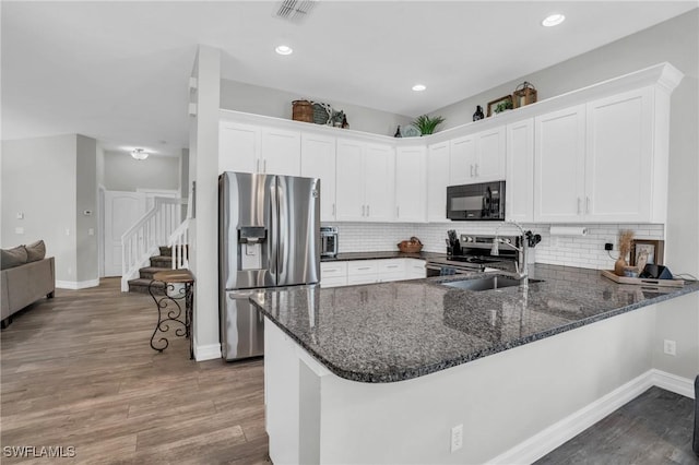 kitchen featuring stainless steel appliances, white cabinets, and kitchen peninsula