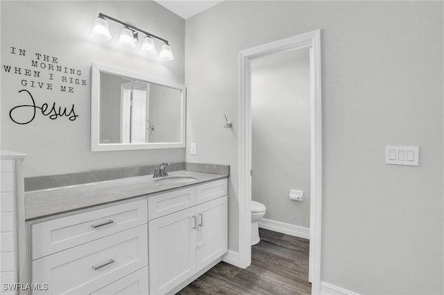 bathroom featuring wood-type flooring, toilet, and vanity