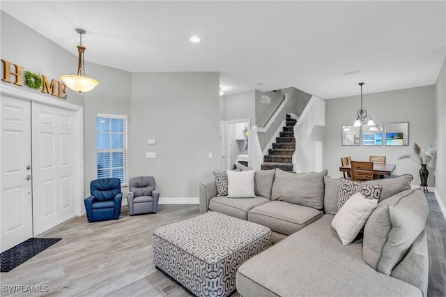 living room with an inviting chandelier and light hardwood / wood-style floors