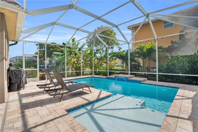 view of pool featuring a grill, glass enclosure, and a patio area