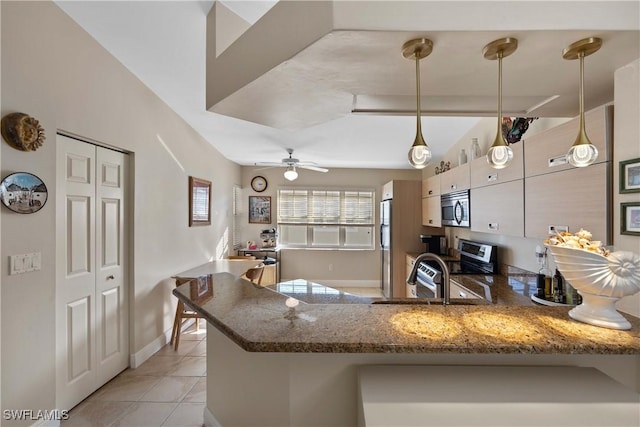 kitchen with ceiling fan, light tile patterned floors, kitchen peninsula, pendant lighting, and stainless steel appliances