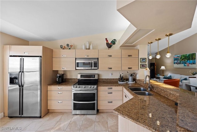 kitchen with sink, dark stone countertops, light brown cabinetry, and appliances with stainless steel finishes