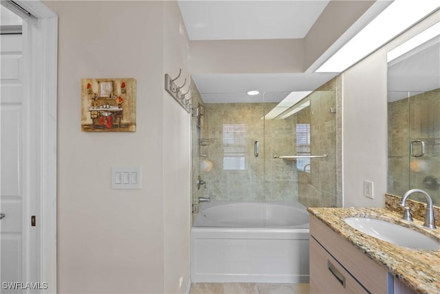 bathroom featuring enclosed tub / shower combo and vanity