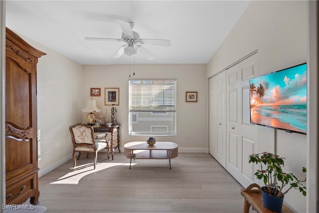 sitting room with light wood-type flooring and ceiling fan