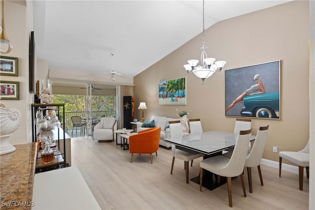 dining room with ceiling fan with notable chandelier, light hardwood / wood-style flooring, and vaulted ceiling