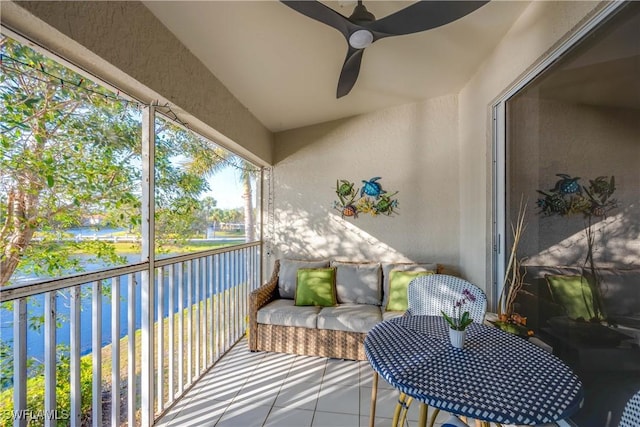 balcony with ceiling fan and a water view