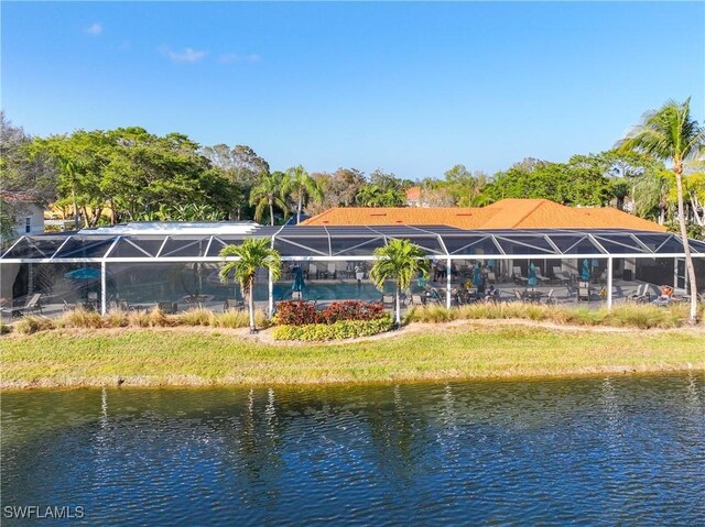 rear view of property with a lawn and a water view