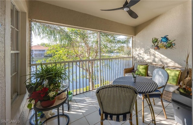 balcony with ceiling fan and a water view