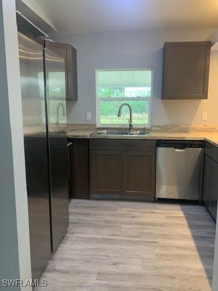 kitchen with stainless steel appliances, sink, dark brown cabinets, and light hardwood / wood-style flooring