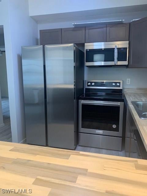 kitchen with butcher block counters and appliances with stainless steel finishes