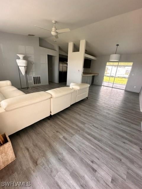 unfurnished living room featuring ceiling fan, hardwood / wood-style floors, and vaulted ceiling