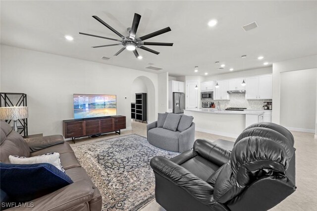 living room with ceiling fan and sink