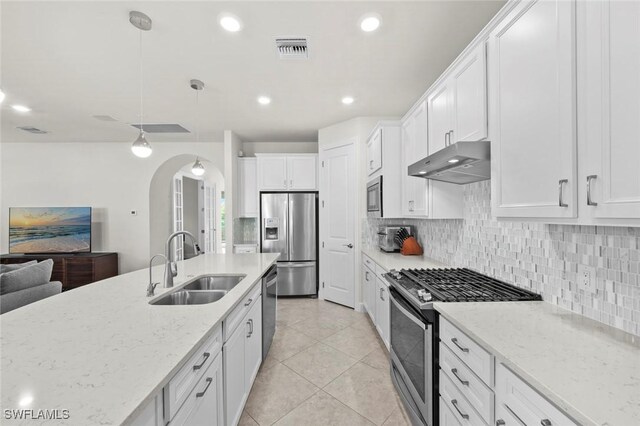 kitchen with pendant lighting, sink, white cabinetry, light stone countertops, and appliances with stainless steel finishes