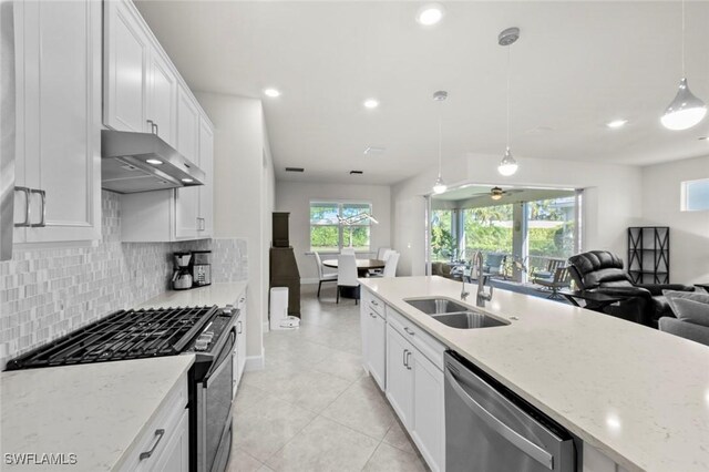 kitchen featuring decorative light fixtures, sink, white cabinets, and stainless steel appliances