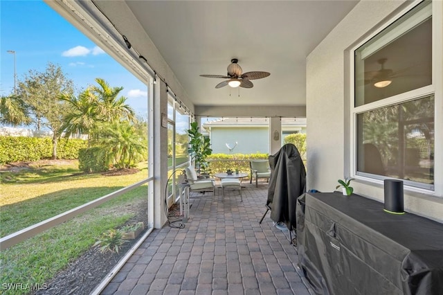 sunroom featuring ceiling fan and plenty of natural light