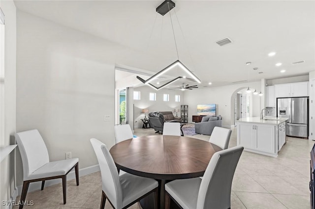 dining area with ceiling fan, light tile patterned floors, and sink