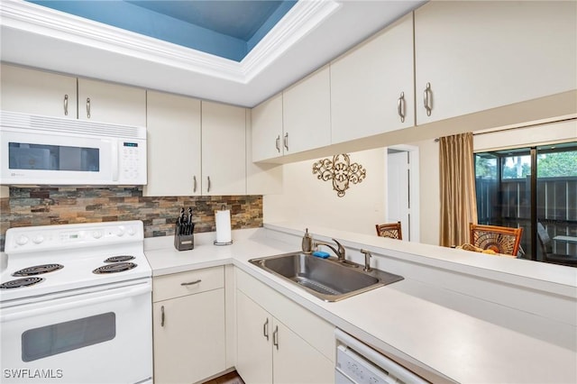 kitchen featuring tasteful backsplash, sink, white appliances, and white cabinetry